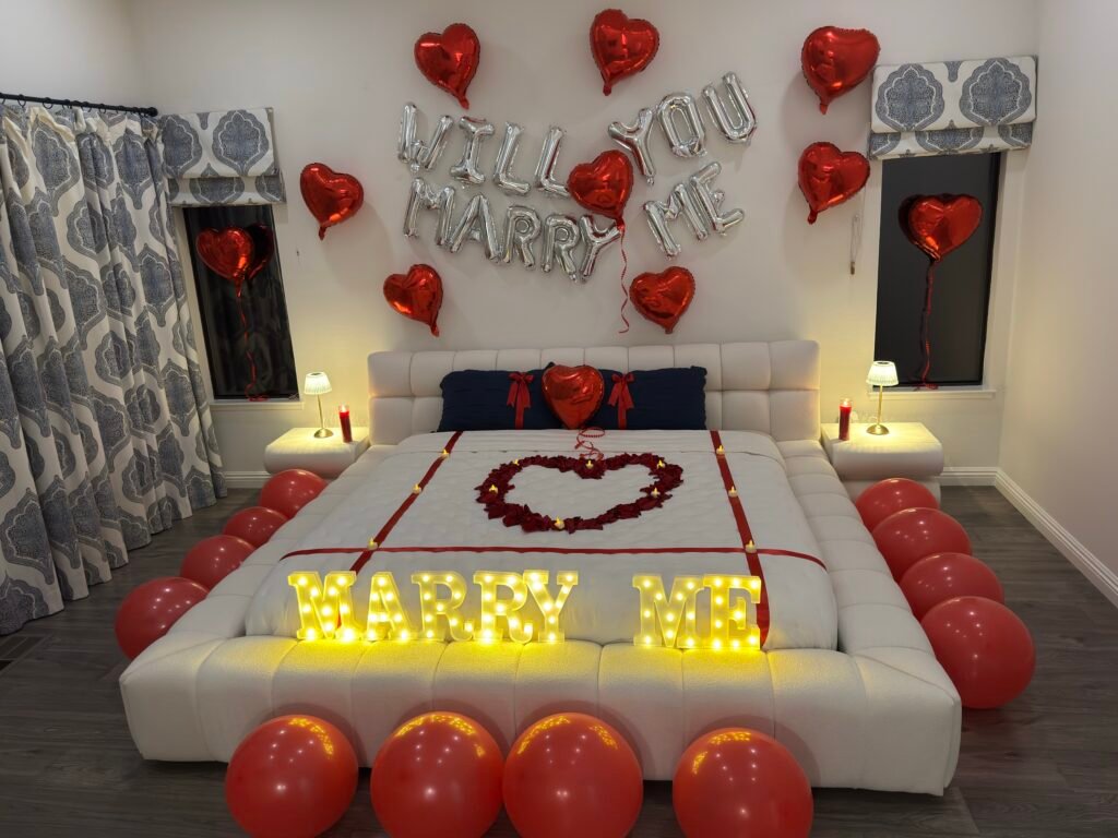 Airbnb proposal setup in Napa Valley with "Will You Marry Me" balloons, heart balloons, "Marry Me" light up letters and rose petals